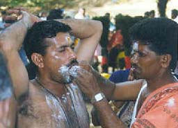 devotee has his cheeks pierced by a miniature spear 